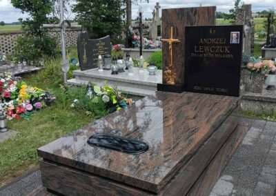 nagrobek z krzyżem stojącym z różami